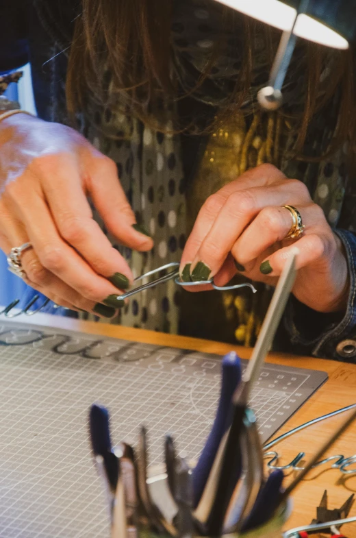 a man is working with soing silver and pliers