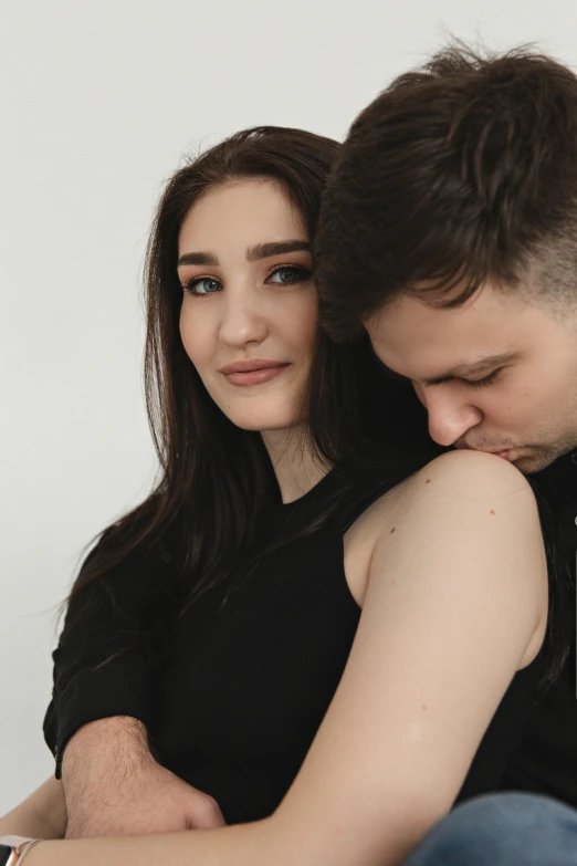 young man emcing woman with eyes closed on white background