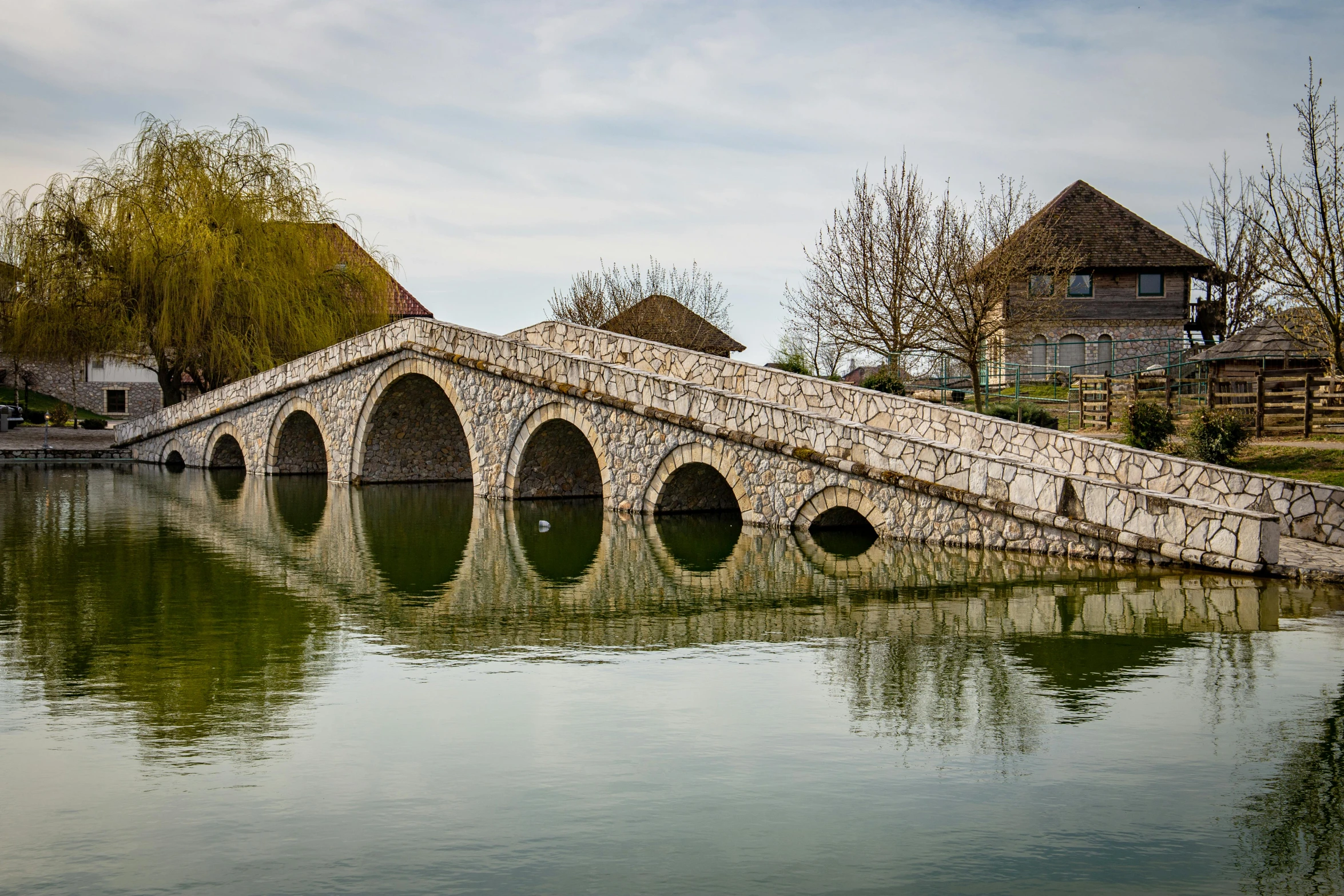 a bridge over water surrounded by a few buildings