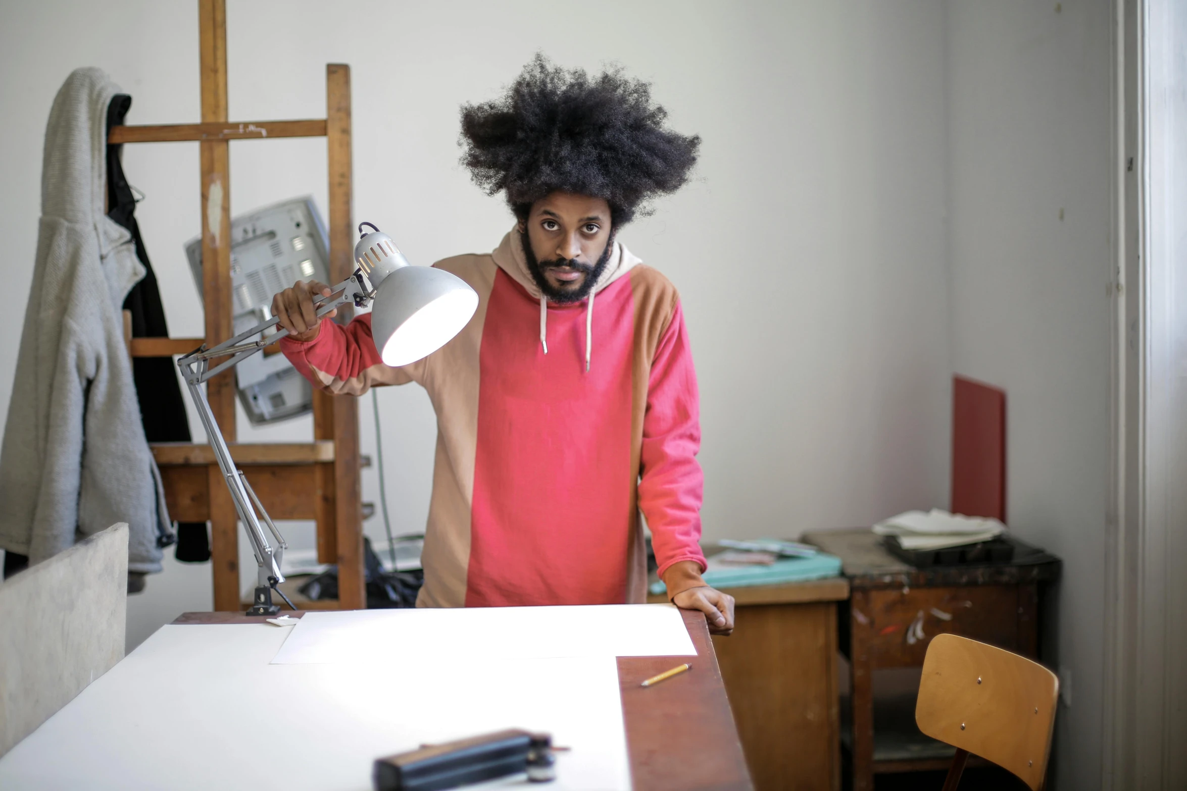 a man wearing a costume with a big afro holding up a lamp