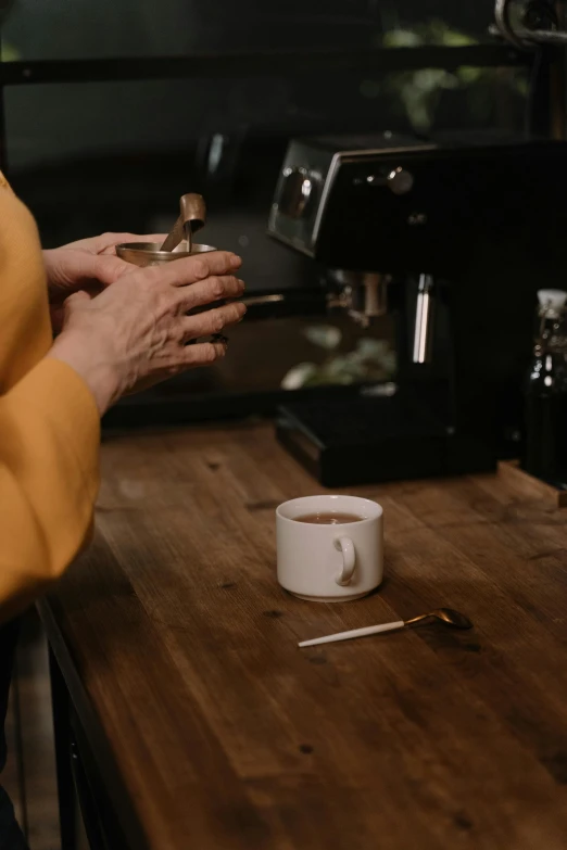 woman holding coffee cup with coffee beans on table