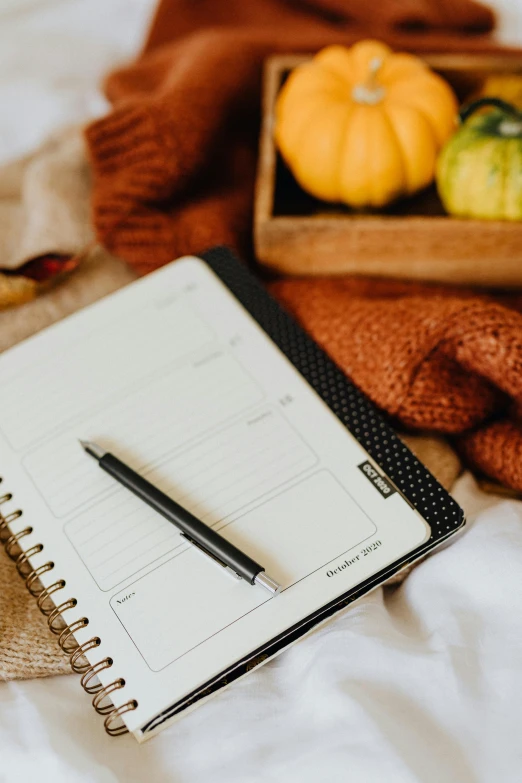 a notepad and pen sitting on top of a bed