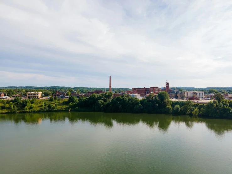 a body of water with a factory in the distance