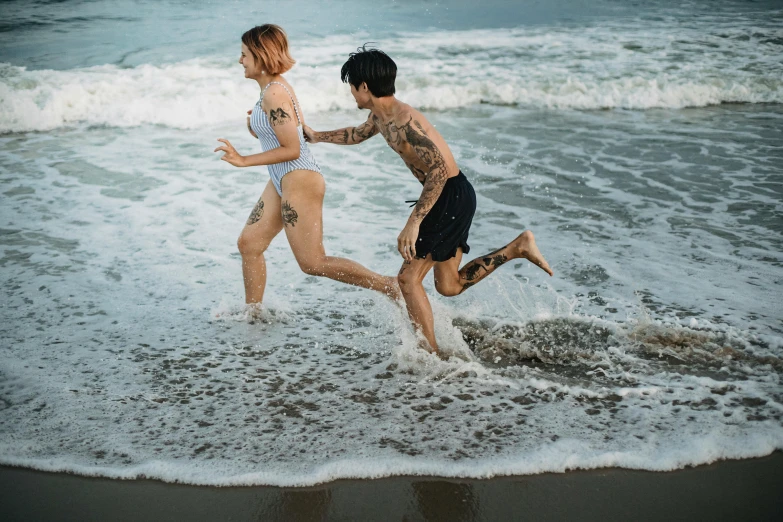 two people run into the surf near the shore