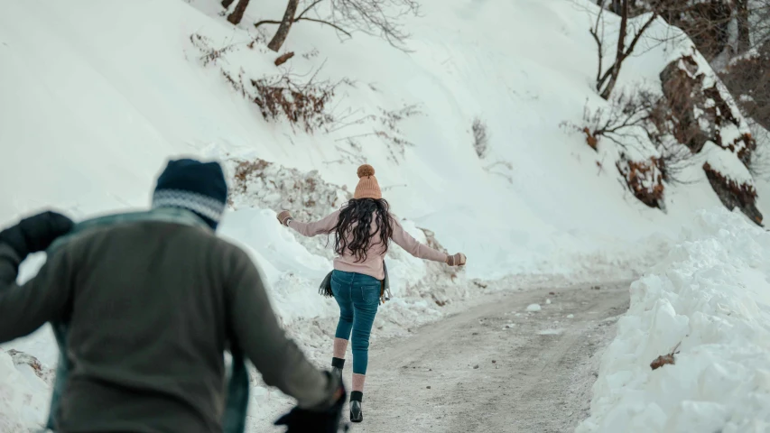 two people walking down a snow covered road