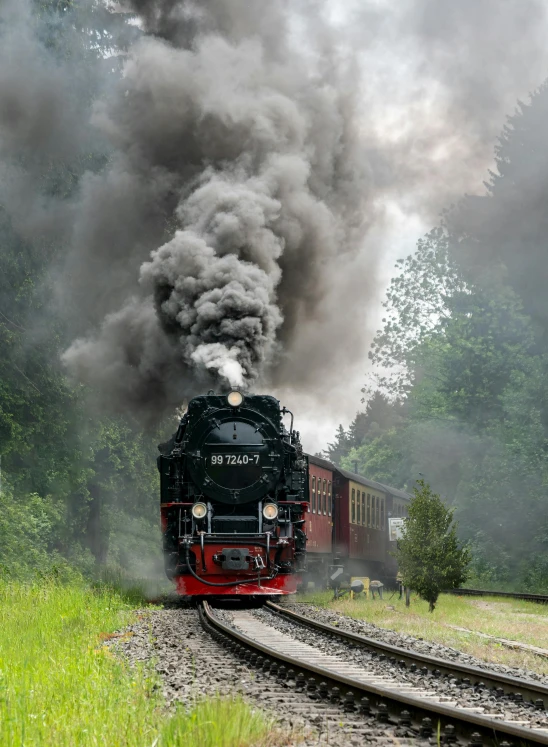 black steam coming from the engine of a locomotive