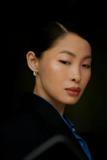 a woman with her eyes closed and a dark background