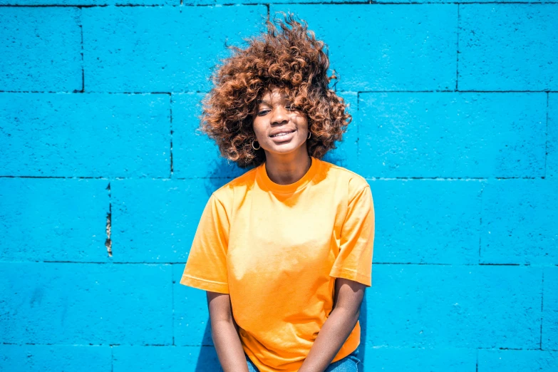 a young woman is smiling while wearing an orange shirt