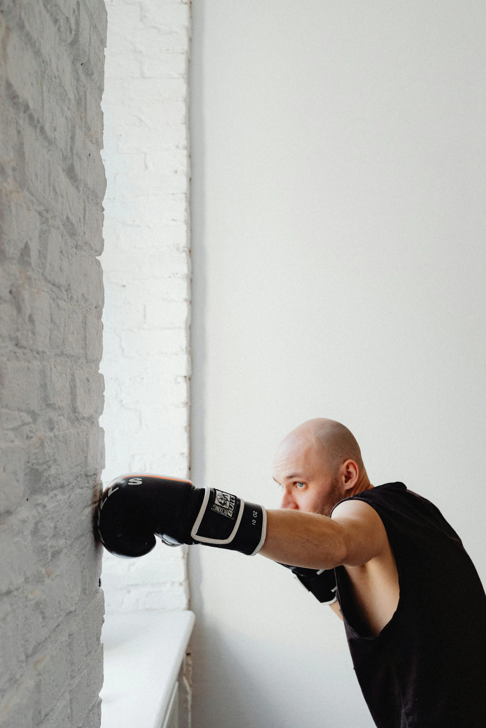 a man is standing in a room while wearing boxing gloves