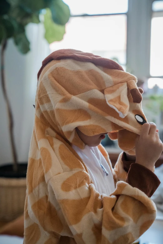 a woman in a yellow and white robe covering her face with a banana towel