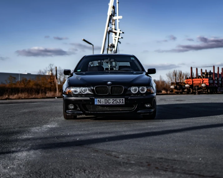 black bmw parked in front of a crane