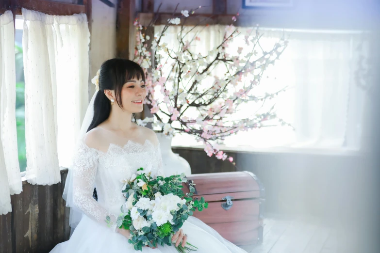 bride posing for po at the window in her wedding dress