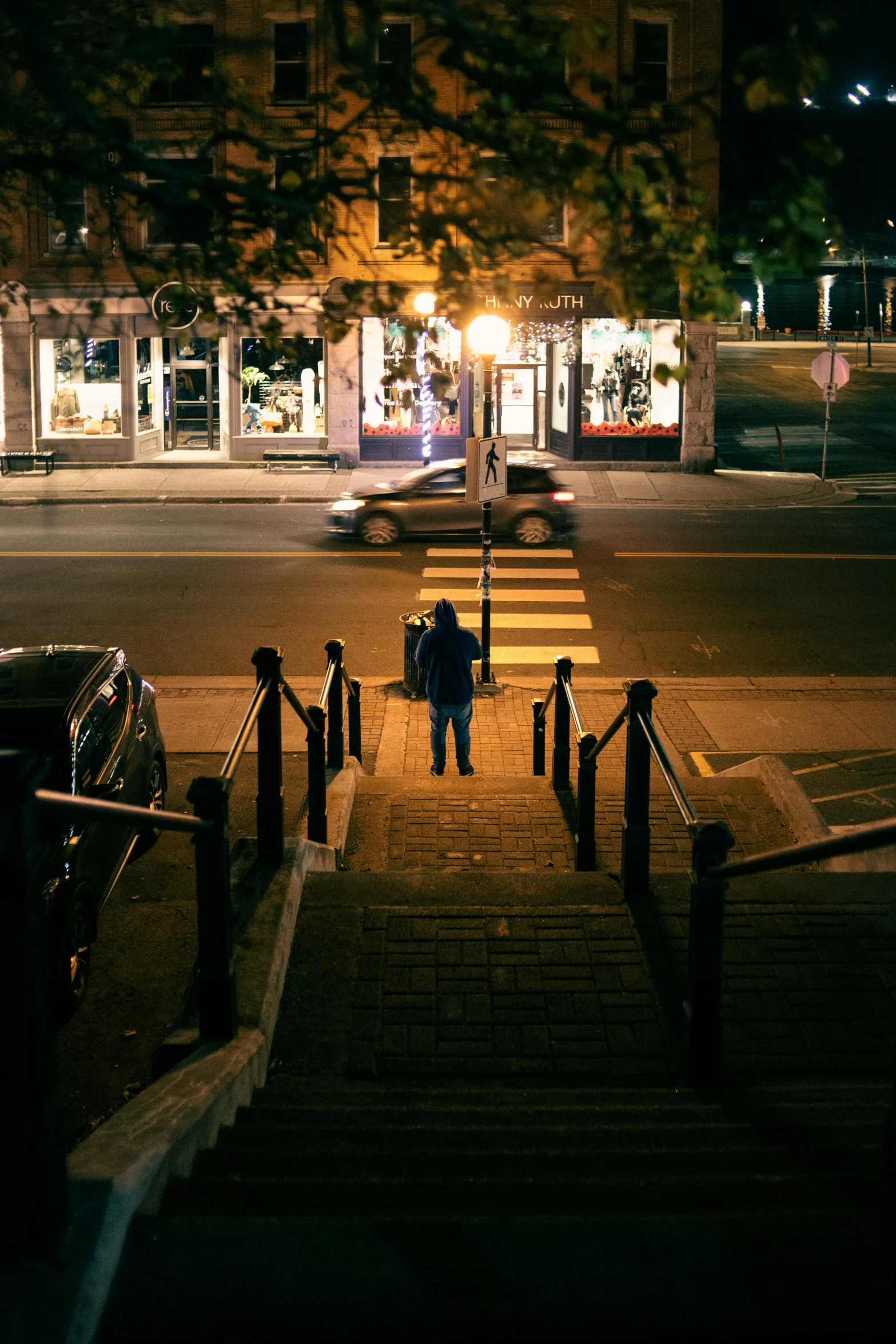 a man stands at the entrance to a restaurant on a steep stairway