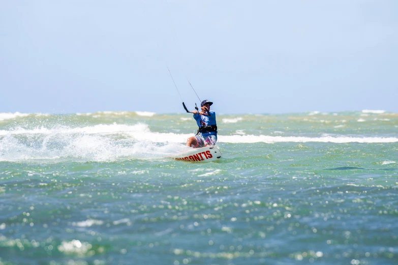 the man is windsurfing on the ocean in the daytime