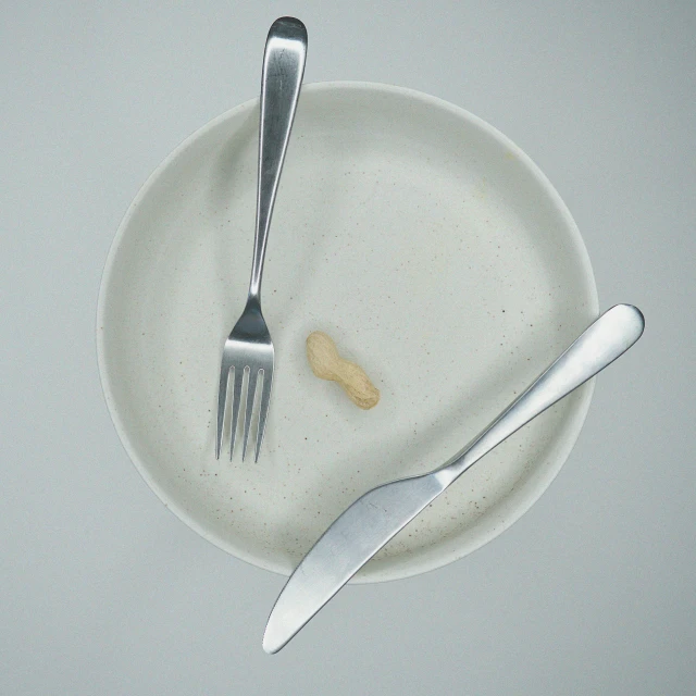 a couple of knives and fork sitting on top of a white plate