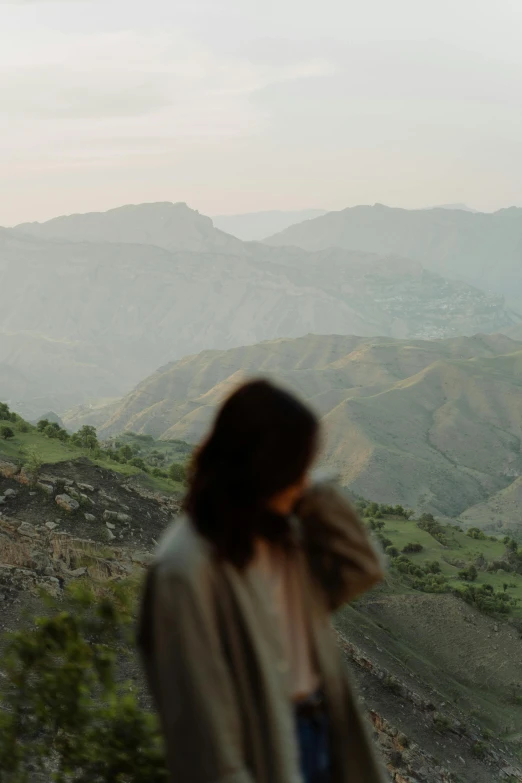 the back end of a woman looking at some mountains