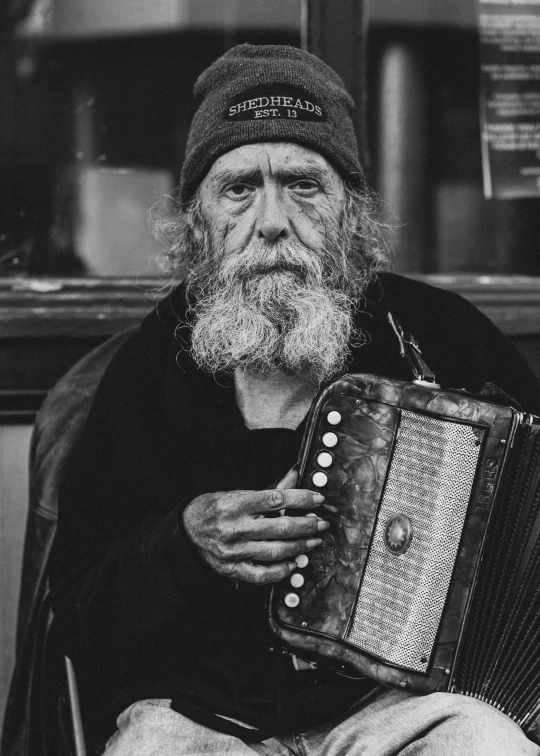 an old man playing an accordion on the street