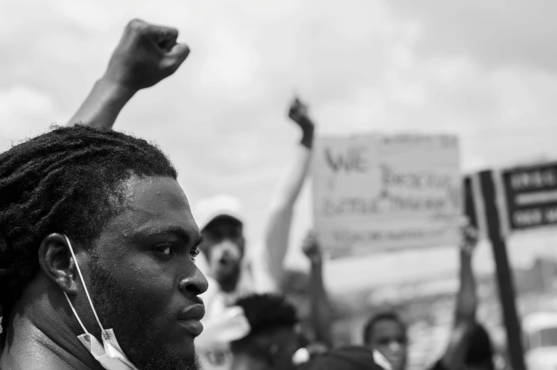 black and white pograph of man raising up fist