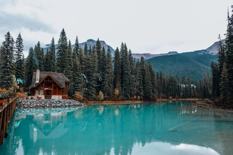 a mountain lake with a wooden jetty and a house on the side