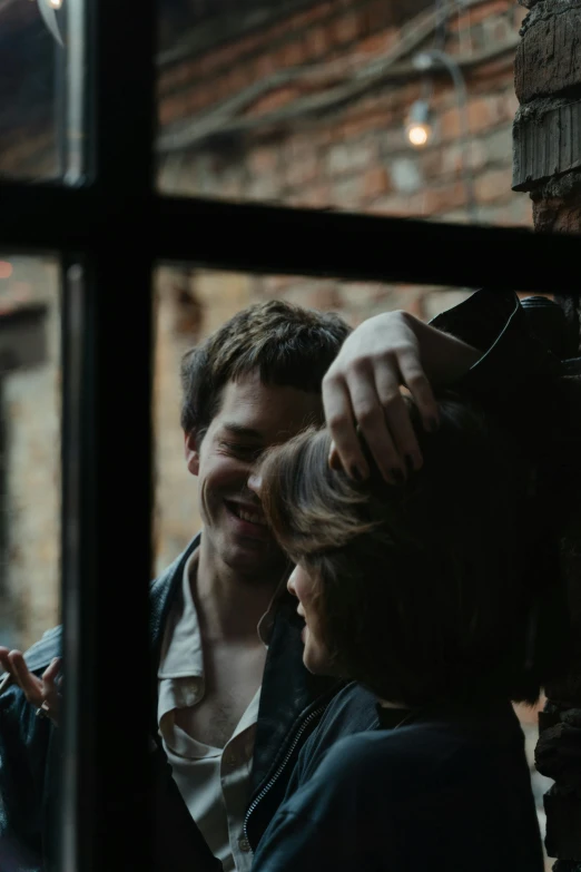 two people standing in front of a window