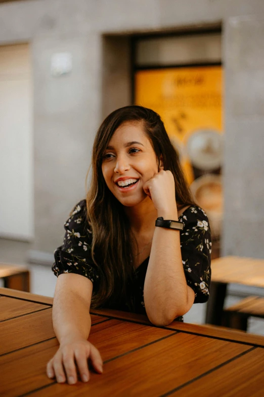 a smiling young woman sitting at a table