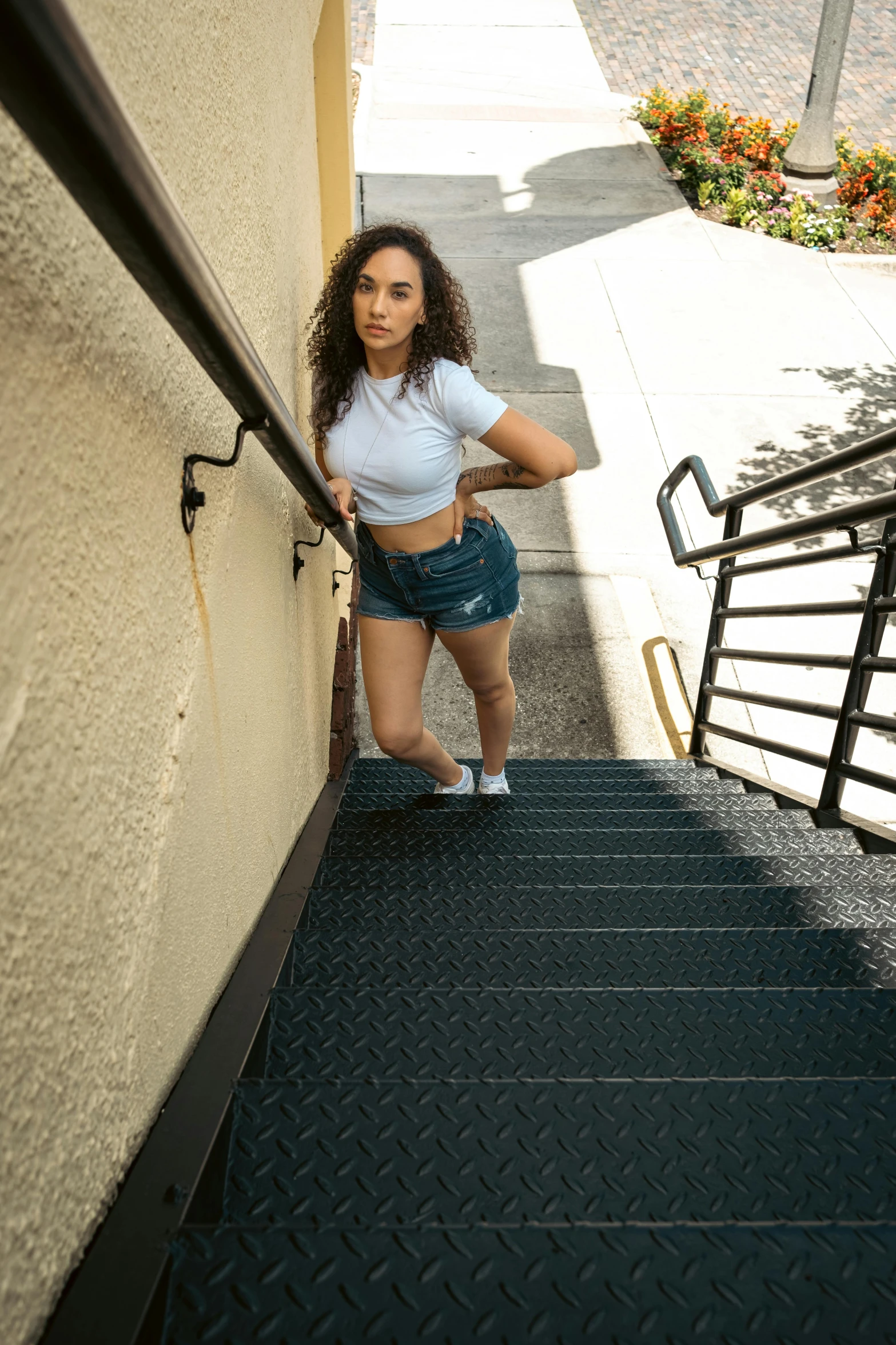 a woman in white shirt and skirt on stairs