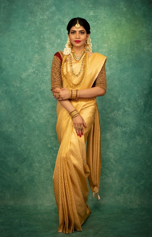 an indian woman wearing a yellow sari and a gold necklace