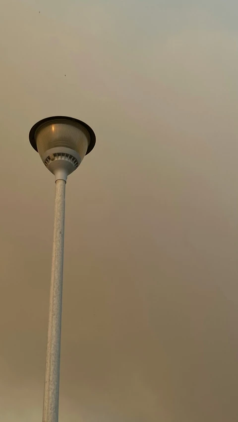 a street light in the middle of a cloudy sky