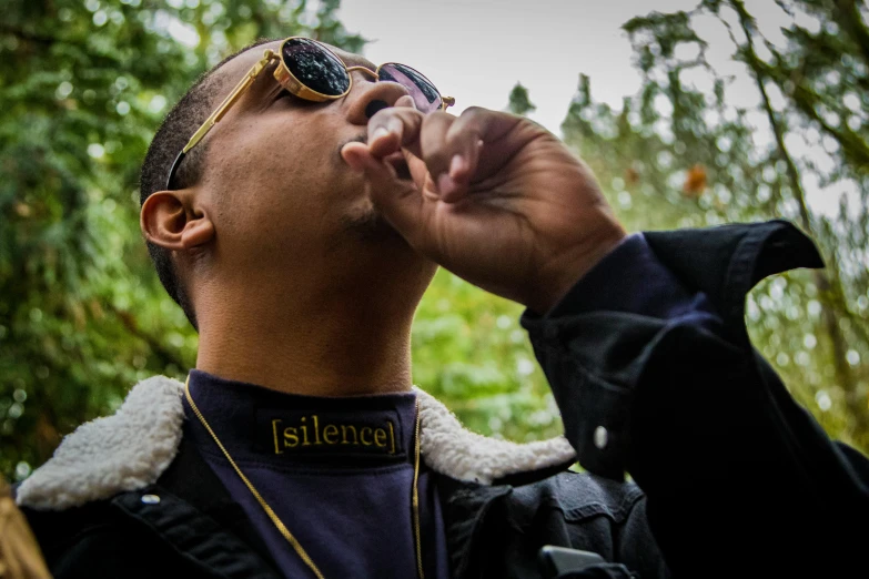 the person is taking a drink in the woods