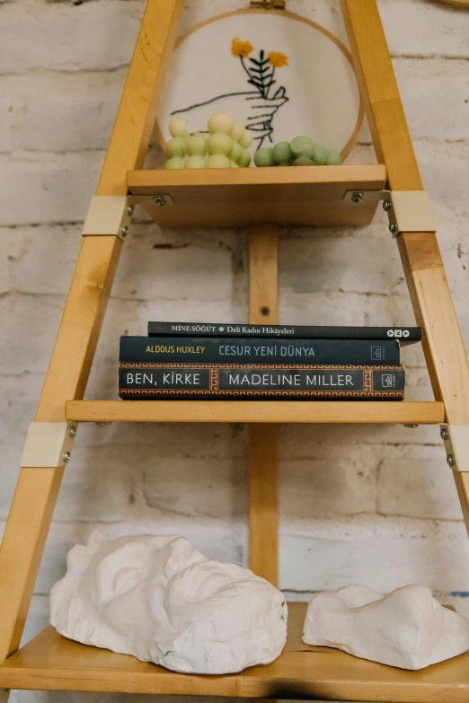 books and a vase on a shelf sitting on the floor