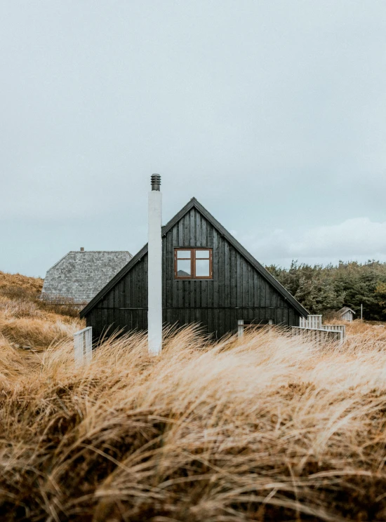 a building sitting on the side of a mountain in the grass