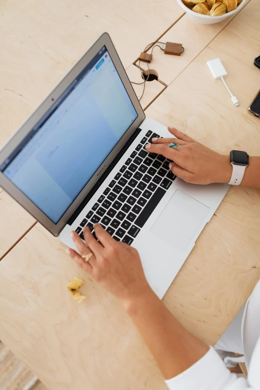 a woman sitting at her laptop, working on the keyboard