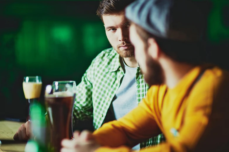 a couple of people sitting at a table in front of a beer