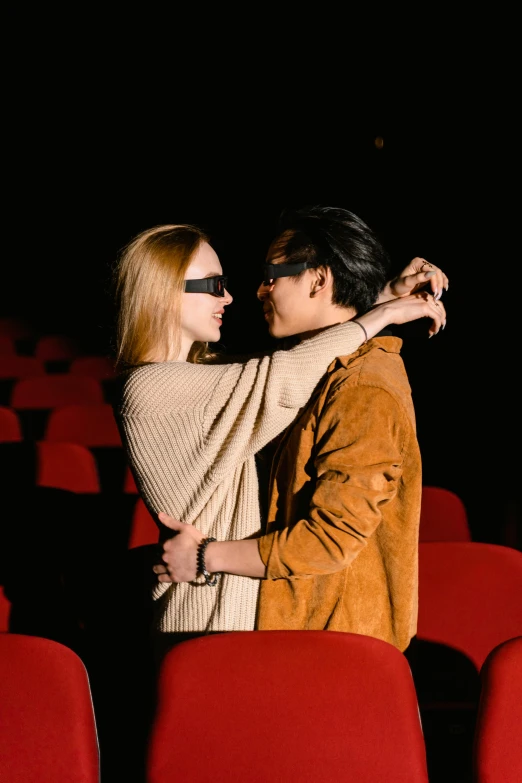 a couple are standing next to each other in a theater