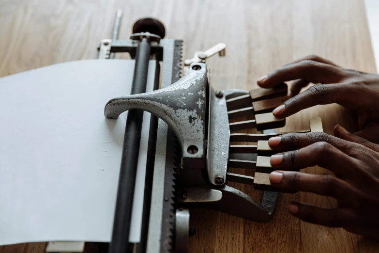 the hands are making a paper that is being pressed