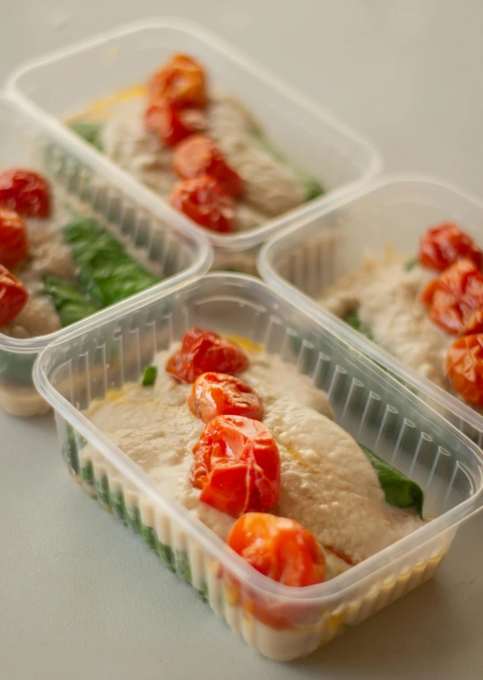 three containers filled with various types of food