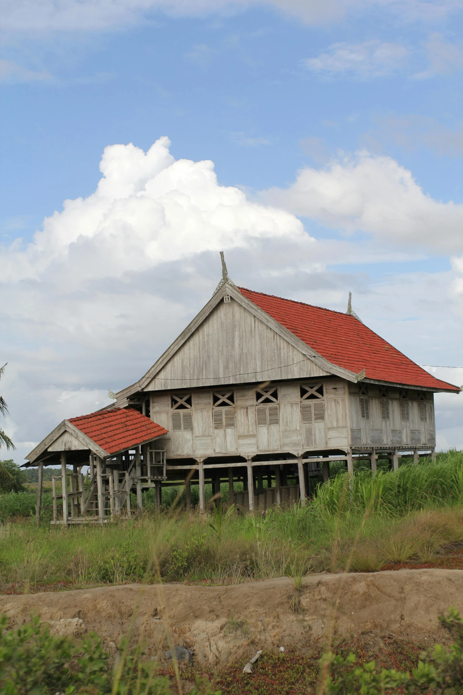 two wooden houses stand in the middle of the field