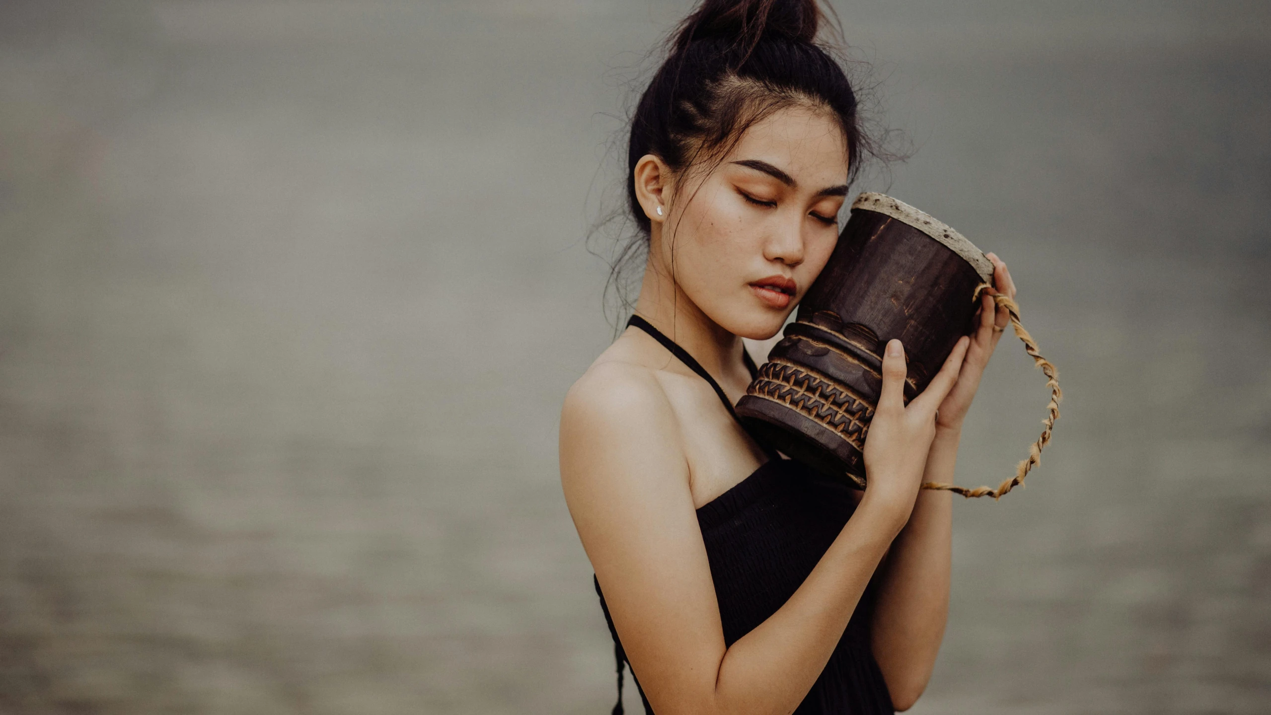 a woman is holding a mug on her shoulder