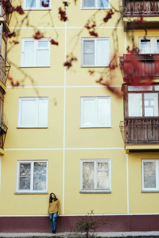 a young lady is standing in front of a tall building