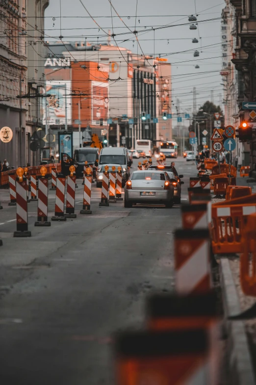 a city street with cars, traffic cones and buildings