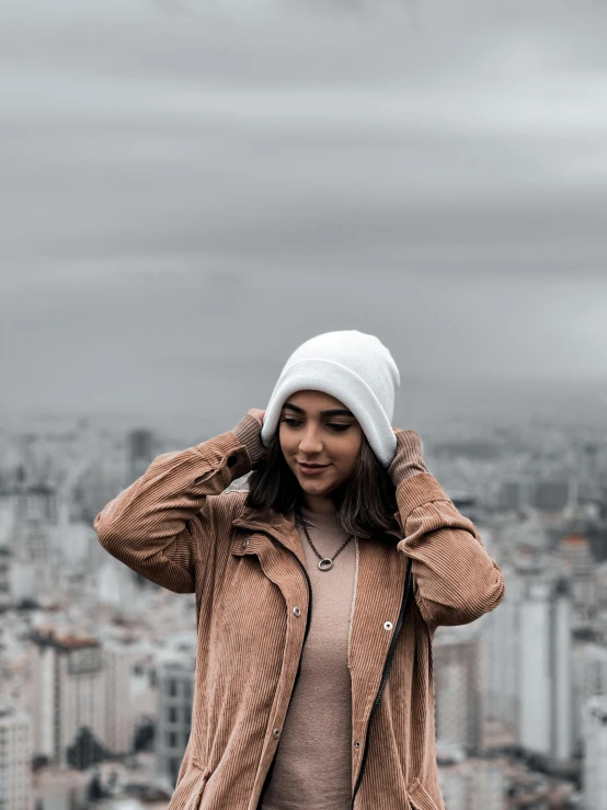 a woman wearing a white hat and a brown jacket