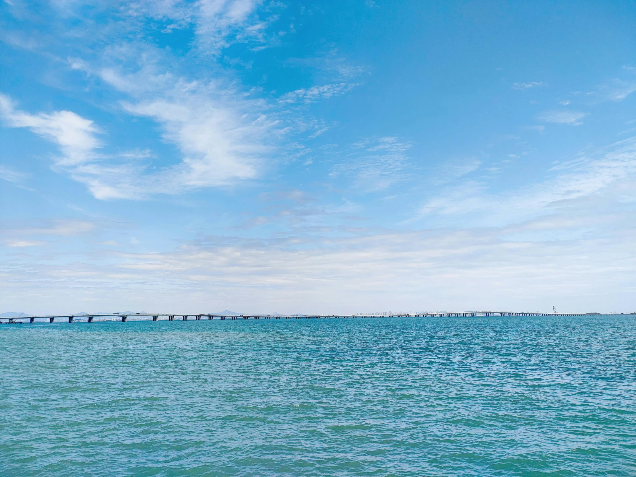 a boat sits in the water with a bridge in the background