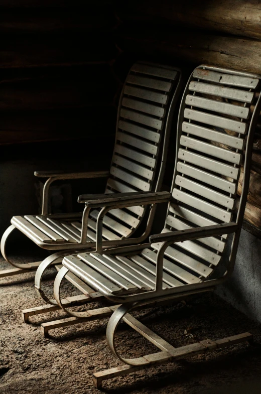 a metal bench with wooden slats sits next to another one