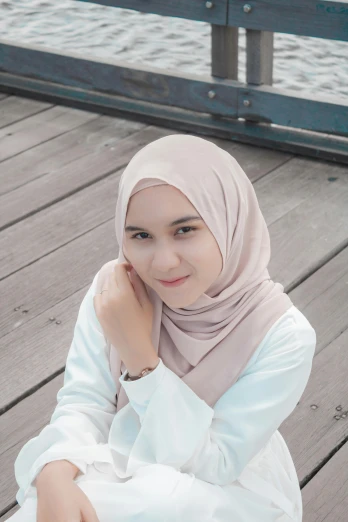 a girl in hijab posing on the dock