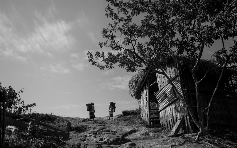 an old building with wood siding near a tree