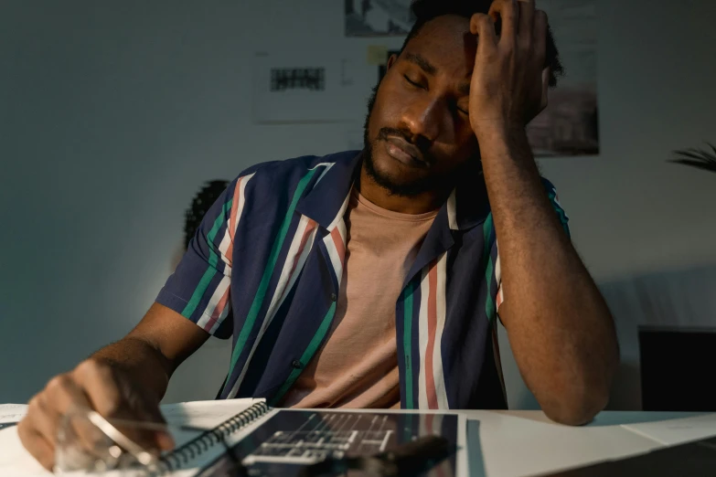 a man with his hand up as he sits at his computer