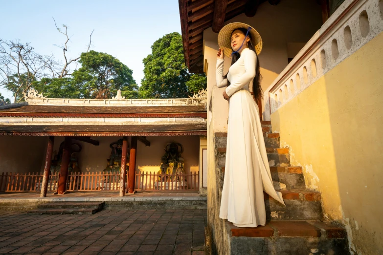 a woman in a hat and dress holding a umbrella