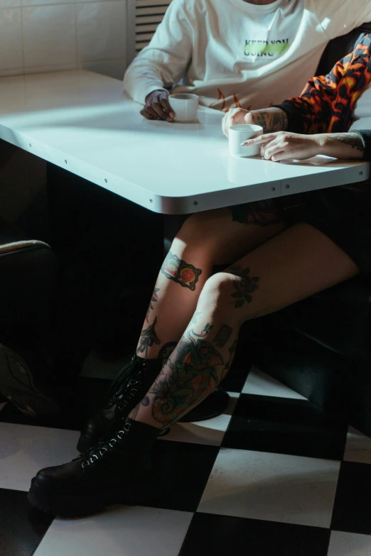 a woman is sitting at a white table