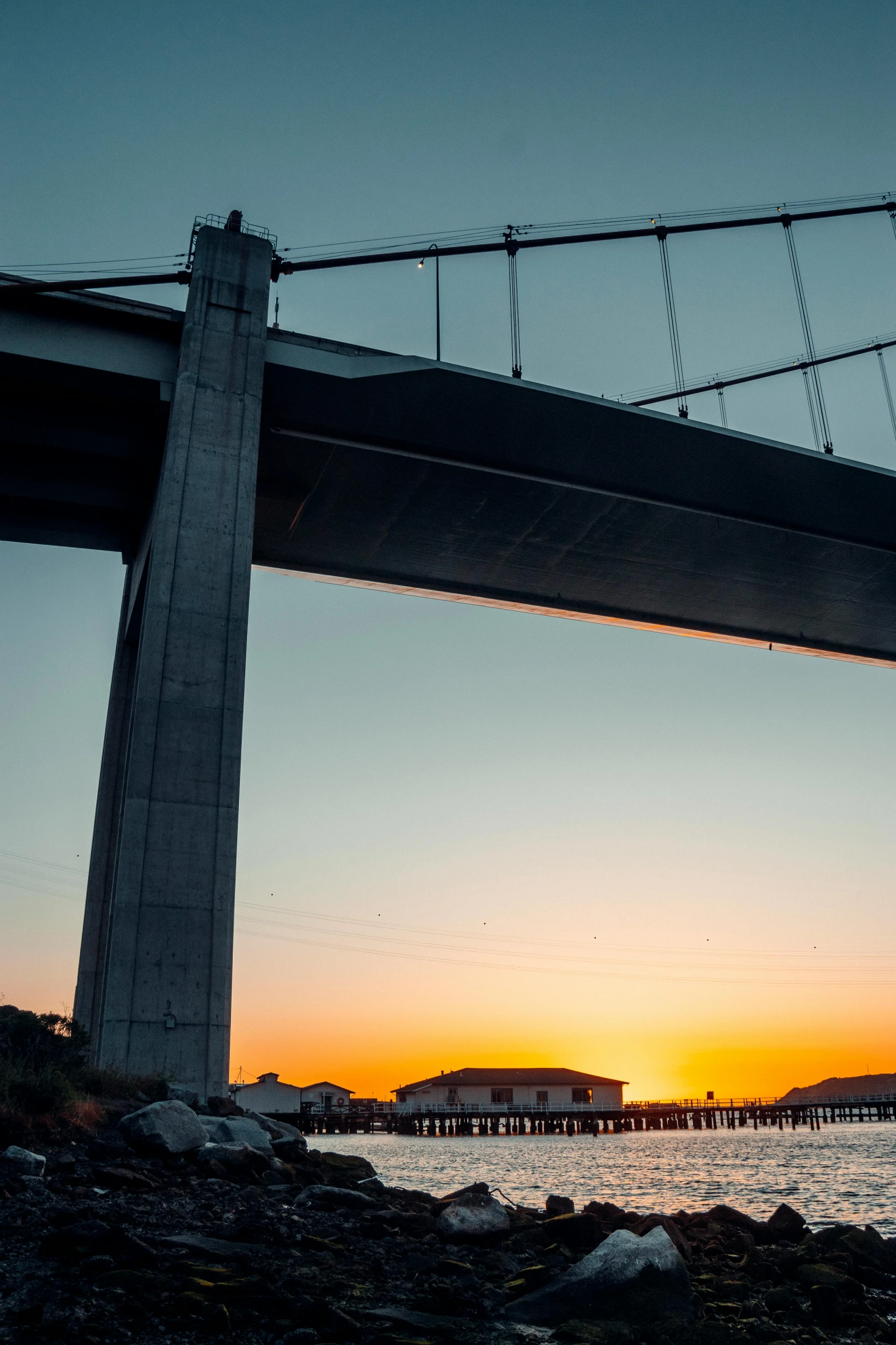 the view from underneath a bridge at sunset