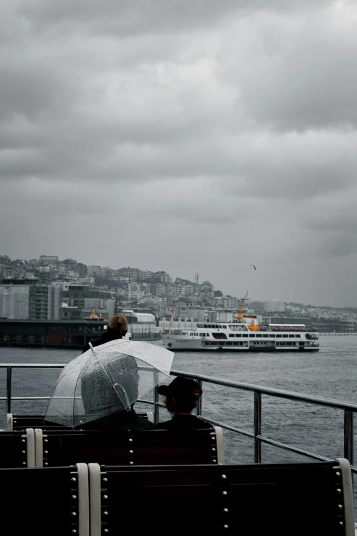 two people are sitting on a bench on the side of a boat